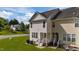 The back exterior of this home has vinyl siding, a green lawn and a small patio area at 202 Wimbledon Ct, Clayton, NC 27520
