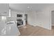 Bright kitchen area with white cabinetry, quartz countertops, and stainless steel appliances at 202 Wimbledon Ct, Clayton, NC 27520