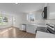 Bright kitchen featuring white cabinetry, stainless steel appliances, and wood-look flooring at 202 Wimbledon Ct, Clayton, NC 27520