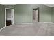 Bedroom with neutral carpet and green walls, with entrances to bathroom and hallway at 2053 Alderman Way, Creedmoor, NC 27522