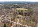 Expansive aerial view of a secluded home nestled in a wooded area with an extra long driveway at 2053 Stillwood Dr, Youngsville, NC 27596