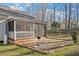 Exterior view of cozy screened porch with grill and patio area in a spacious backyard at 2053 Stillwood Dr, Youngsville, NC 27596
