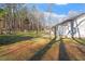 Exterior view of sprawling backyard with shade trees, play area, and lush green lawn at 2053 Stillwood Dr, Youngsville, NC 27596