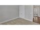 Carpeted bedroom with a closet and view to another room through an open door at 215 Mystic Pine Pl, Apex, NC 27539