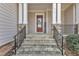 Charming front entrance with stone steps, a welcoming sunflower decor, and a red door at 215 Mystic Pine Pl, Apex, NC 27539