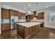 Spacious kitchen featuring a large center island with stainless steel appliances and dark wood cabinets at 215 Mystic Pine Pl, Apex, NC 27539