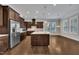 Modern kitchen with stainless steel appliances, dark wood cabinets, and a large center island at 215 Mystic Pine Pl, Apex, NC 27539