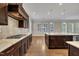Bright, updated kitchen with stainless appliances, cooktop, dark wood cabinets, and adjacent living area access at 215 Mystic Pine Pl, Apex, NC 27539