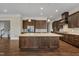 Open kitchen with stainless steel appliances, a large island, and dark wood cabinets offer ample space for cooking at 215 Mystic Pine Pl, Apex, NC 27539