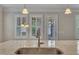 Up close view of a spacious kitchen island with stainless steel sink and faucet, with bright windows in the background at 215 Mystic Pine Pl, Apex, NC 27539