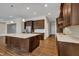 Bright kitchen features a center island, stainless steel appliances, and dark wood cabinetry with plenty of storage at 215 Mystic Pine Pl, Apex, NC 27539