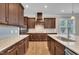 Stylish kitchen showcasing dark wood cabinetry, stone countertops, stainless steel appliances, and ample counter space at 215 Mystic Pine Pl, Apex, NC 27539