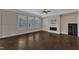 Bright living room with hardwood floors, white shutters on the windows, and modern fireplace at 215 Mystic Pine Pl, Apex, NC 27539