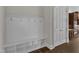 Bright mudroom featuring a white storage bench with cubbies and coat hooks, complemented by hardwood floors at 215 Mystic Pine Pl, Apex, NC 27539