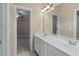 Bright bathroom with double vanity, a large mirror, tile flooring, and natural light at 2308 Carriage Oaks Dr, Raleigh, NC 27614