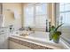A bright bathroom features a tub with tile surround, a shower, and a dual sink vanity at 2308 Carriage Oaks Dr, Raleigh, NC 27614