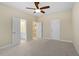 A carpeted bedroom features neutral walls, a ceiling fan, and access to other rooms at 2308 Carriage Oaks Dr, Raleigh, NC 27614