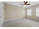 A carpeted bedroom features neutral walls, a ceiling fan, and two windows for natural light at 2308 Carriage Oaks Dr, Raleigh, NC 27614