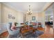 Open dining area featuring a modern chandelier, large windows, and a wooden accent table at 2308 Carriage Oaks Dr, Raleigh, NC 27614