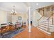 Bright dining room featuring hardwood floors, chandelier, and staircase with white railing at 2308 Carriage Oaks Dr, Raleigh, NC 27614