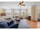 Inviting living room featuring large windows, ceiling fan, and comfortable sofas, providing ample seating at 2308 Carriage Oaks Dr, Raleigh, NC 27614