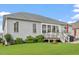 A charming backyard view with green grass, lush landscaping, deck, and gray siding at 2554 Club Level Dr, Apex, NC 27523