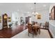 Dining room featuring hardwood floors, chandelier, and a view of the living area and front door at 2554 Club Level Dr, Apex, NC 27523