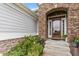 Close up of front door entryway, showcasing a stone archway and colorful potted flowers at 2554 Club Level Dr, Apex, NC 27523