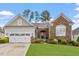 Charming single Gathering home featuring a stone facade, manicured lawn, and attached two car garage at 2554 Club Level Dr, Apex, NC 27523