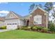 Charming single Gathering home featuring a stone facade, manicured lawn, and attached two car garage at 2554 Club Level Dr, Apex, NC 27523