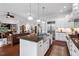 Open kitchen with island and stainless appliances flows into living area, creating an inviting space at 2554 Club Level Dr, Apex, NC 27523