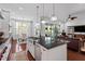 Open kitchen with island and stainless appliances flows into living area and breakfast nook, creating an inviting space at 2554 Club Level Dr, Apex, NC 27523