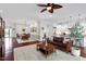 Open-concept living space with dark hardwood floors and abundant natural light flowing into dining and kitchen areas at 2554 Club Level Dr, Apex, NC 27523