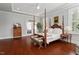 Bedroom featuring a four-poster bed, hardwood floors, and bright natural light at 2554 Club Level Dr, Apex, NC 27523