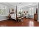 Spacious bedroom with tray ceiling, hardwood floors, plantation shutters, and comfortable seating area at 2554 Club Level Dr, Apex, NC 27523