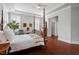 Elegant bedroom featuring tray ceiling, plantation shutters, hardwood floors, and comfortable sitting area at 2554 Club Level Dr, Apex, NC 27523