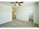 A blank carpeted bedroom features neutral tones, a ceiling fan, and multiple doorways, awaiting personalization at 310 Shale Creek Dr, Durham, NC 27703