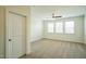A bright bedroom boasts multiple windows, neutral carpet, and a ceiling fan for a comfortable living space at 310 Shale Creek Dr, Durham, NC 27703