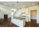 Open concept kitchen with island and granite countertops, hardwood floors and white cabinets at 310 Shale Creek Dr, Durham, NC 27703