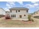Back of house with stone patio and grass, with flowering shrubs at 318 Sylvias Ct, Durham, NC 27703