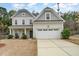 Charming two-story home with a gray roof, a well-manicured lawn, and a spacious two-car garage at 318 Sylvias Ct, Durham, NC 27703