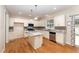Bright kitchen featuring white cabinets, granite counters, stainless appliances, and wood flooring at 318 Sylvias Ct, Durham, NC 27703