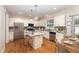 Bright kitchen with white cabinets, granite counters, stainless appliances, breakfast bar and wood floors at 318 Sylvias Ct, Durham, NC 27703