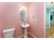 Charming half bathroom features pedestal sink, stylish fixtures, and pink walls at 318 Sylvias Ct, Durham, NC 27703