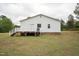 Side view of house with a white siding and wood deck overlooking a grass lawn and trees at 327F Bobbitt Rd, Clayton, NC 27520