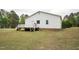 Side view of house with a white siding and wood deck overlooking a grass lawn and trees at 327F Bobbitt Rd, Clayton, NC 27520