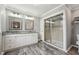 Bathroom with double vanity, granite countertops, wood-style flooring, and a glass-enclosed shower at 327F Bobbitt Rd, Clayton, NC 27520