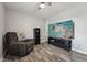 Relaxing bedroom featuring a ceiling fan, TV, gun safe, cozy chair and stylish laminate flooring at 327F Bobbitt Rd, Clayton, NC 27520