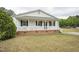View of an inviting home exterior with a covered front porch, white railings and brick foundation at 327F Bobbitt Rd, Clayton, NC 27520