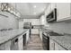 Contemporary kitchen with white cabinets, granite countertops, stainless steel appliances, and wood-style flooring at 327F Bobbitt Rd, Clayton, NC 27520